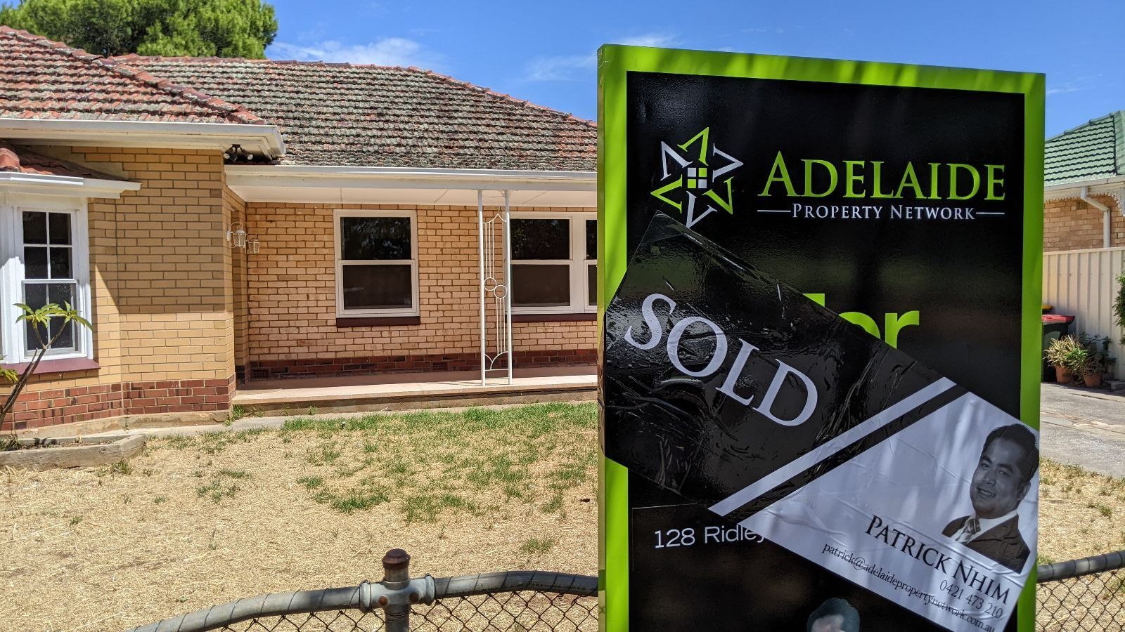 An Adelaide Property Network SOLD sign outside a brick home